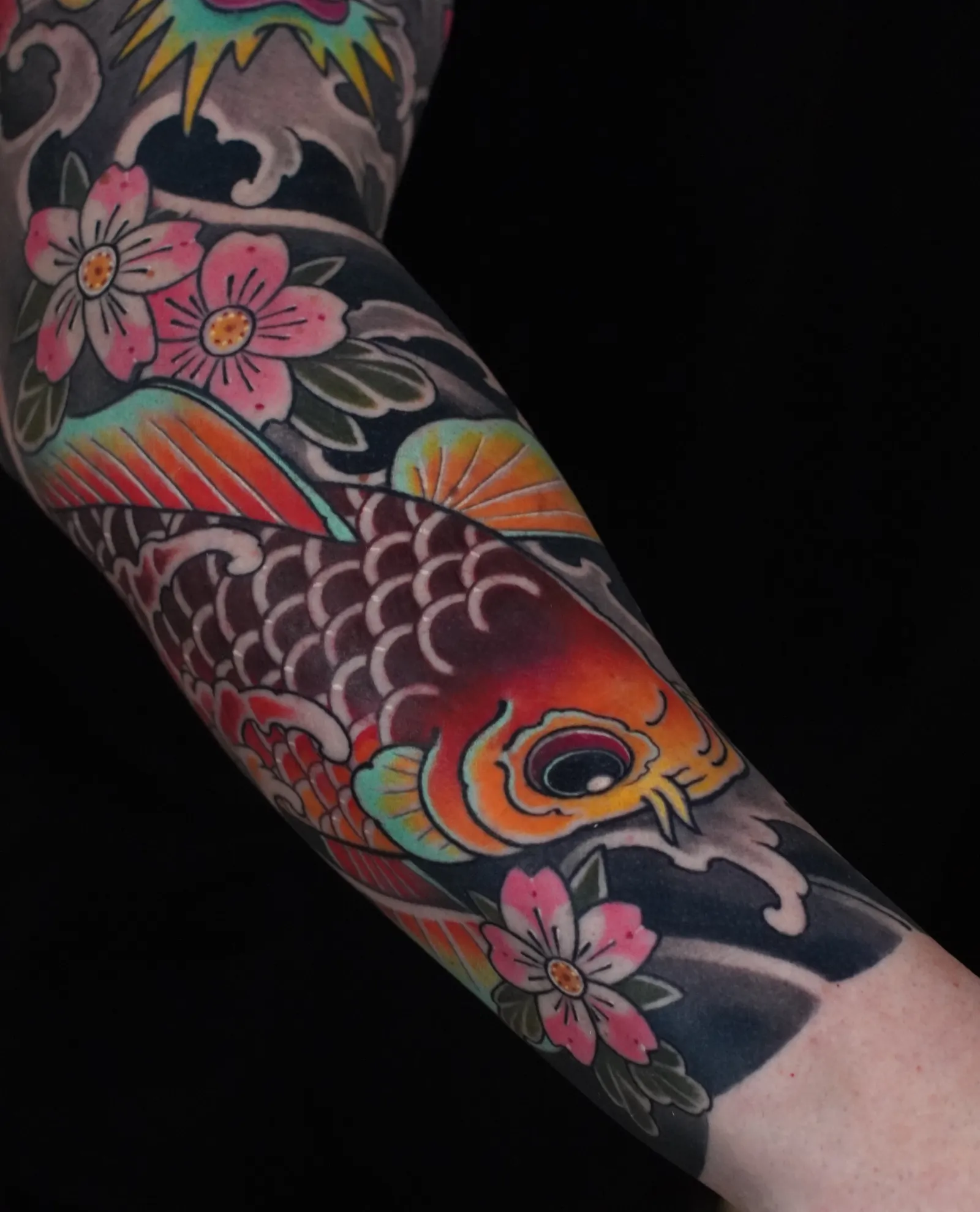 Japanisches Tattoo in Farbe: orangeroter Koi mit rosa Kirschblüten