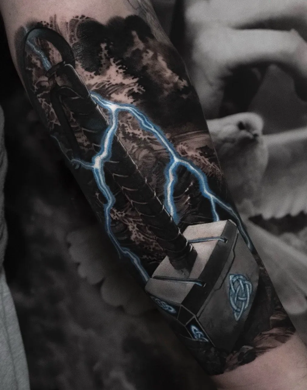 Realistisches Tattoo: Thors Hammer mit Blitzen vor stürmischer See